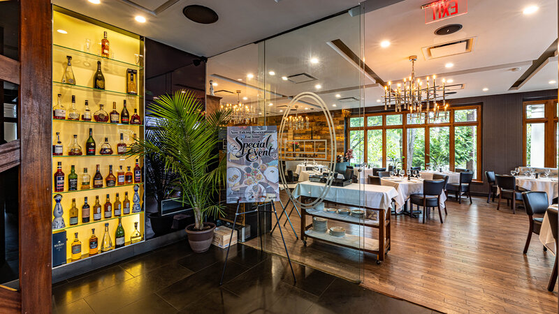 Foyer entrance with view of dining room and a display case of a variety of wine and liquor bottles